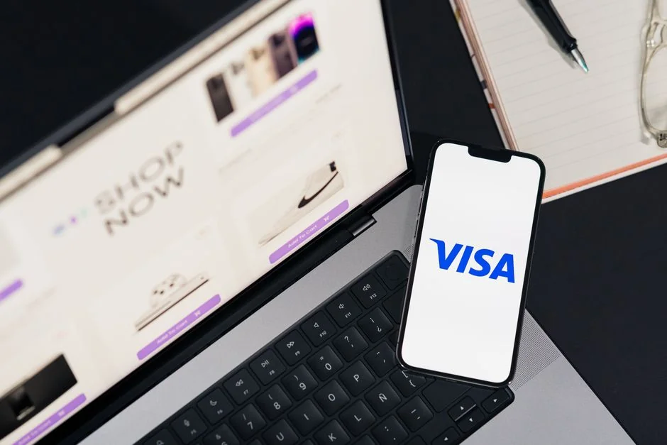 creative-03 Close-up shot of an orange credit card held above a laptop, emphasizing digital payment.